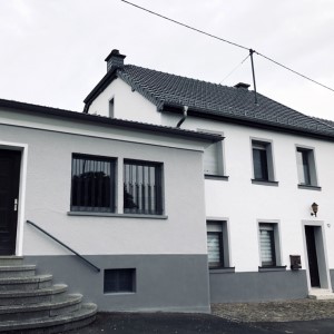 Grau und weiße Fassadenarbeit des Malerbetriebs Benzrath an einem Wohnhaus